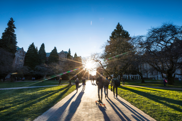students walking into the sunset on UW campus